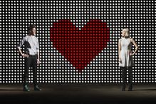 couple in front of lightwall with heartheart