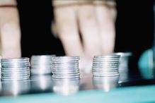 Hands by piles of coins, close-up