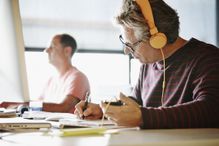 man doing work at desk with headphones on