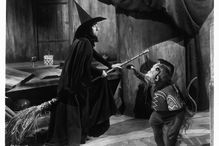 The Wicked Witch on a broom next to her flying monkey in "The Wizard of Oz."