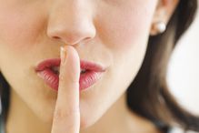 Young woman with finger on lips, close-up