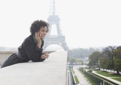 Woman outdoors on her mobile phone by the Eiffel Tower