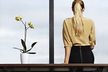 Business woman sitting on desk.