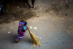 A woman street sweeper sweeping the filthy streets of Kolkata