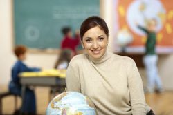 School administrator sitting next to a globe.