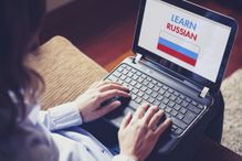 Female learning russian at home with a laptop