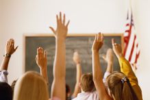 Students raising hands in classroom