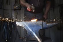 A blacksmith shaping a hot piece of iron on an anvil