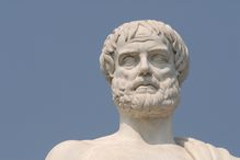 Aristotle statue against a blue sky.