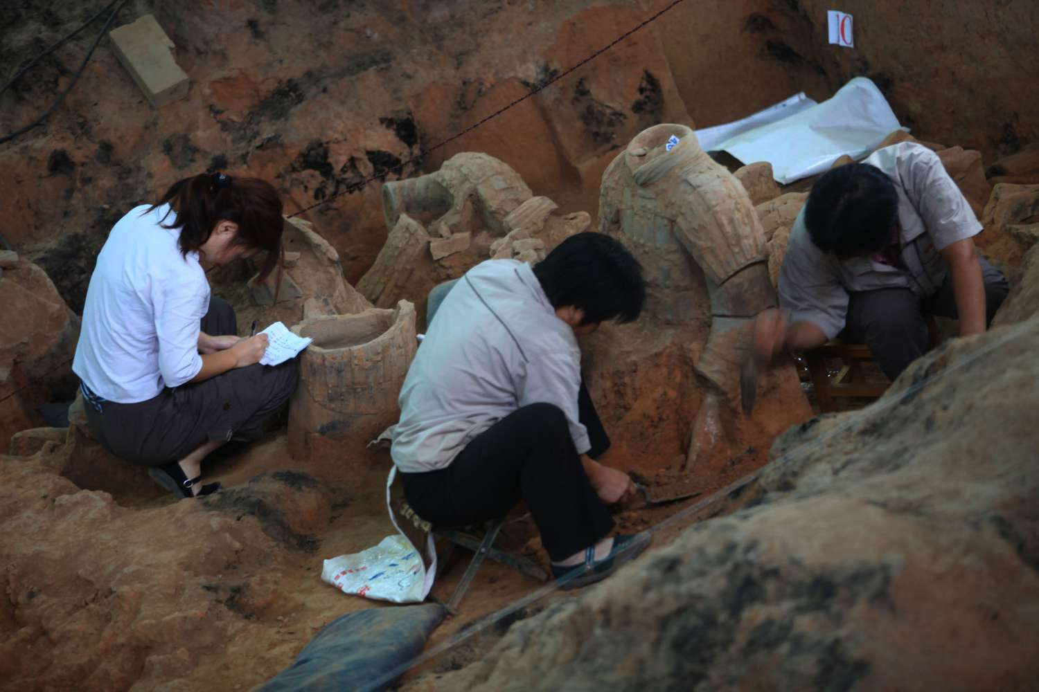 Archaeologists work at the excavation site of No. 1 pit of the Qin Shihuang Terracotta Warriors and Horses Museum in Lintong District of Xian, Shaanxi Province, China. (August 2009)