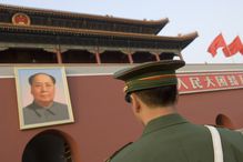 China, Beijing. Soldier standing in front of a portrait of Mao Zedong on the main entrance of the Forbidden City in Beijing