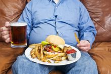 Obese man eating junk food