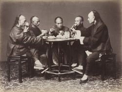 Chinese men with queue hairstyles enjoy a meal