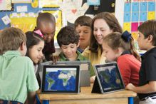 Teacher and students using digital tablets in classroom