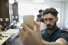 Bearded man taking selfie in barber shop