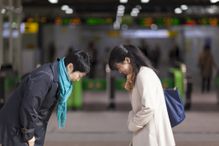 Two Japanese Businesswomen Bowing To Each Other At Station