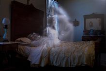 picture of a ghost rising from a dead body in a bed