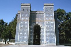 tall, blue structure, two towers connecting one arch, with white four-legged animals dotting the facade