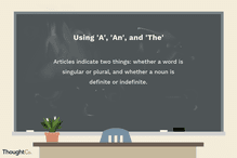 Text on a blackboard: Using A, An, and The. Using them indicates two things: whether a word is singular or plural, and whether a noun is definite or indefinite.