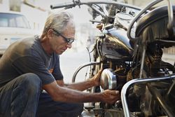 Older man examining his motorcycle