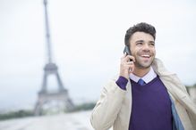 Businessman talking on cell phone by Eiffel Tower