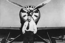 Famous aviator Wiley Post in front of his airplane.