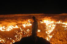 Man standing in front of the Gates of Hell, at Derweze, Turkmenistan.