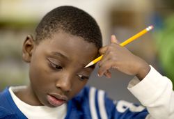 Fourth grade boy works on a math problem.