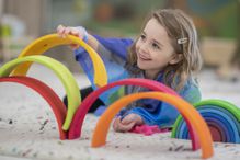 Elementary school girl building a rainbow structure