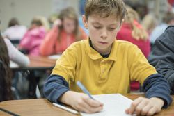 A student writing at his desk