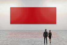 Business people looking at giant red art canvas