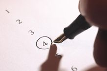 Man filling in questionnaire, close-up of hand