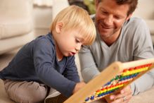 Father and son playing with an abacus.