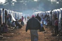 person walking through refugee camp