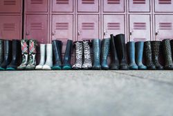Pairs of rain boots in front of school lockers