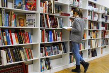 Young woman browsing the shelves at a library.