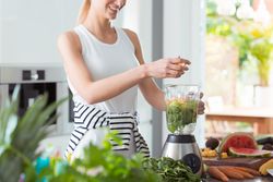 woman using blender to make smoothie