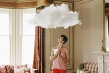 Woman in living room looking at cloud above head