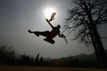 Silhouette of a monk who appears to be holding twin swords.