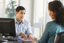 Man and woman talking at desk during job interview