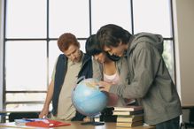 Teenagers looking at a globe