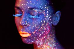 This woman is wearing make-up that glows under a black light.