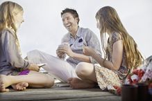 Father playing card game with daughters