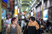 2 young women walking and talking while shopping