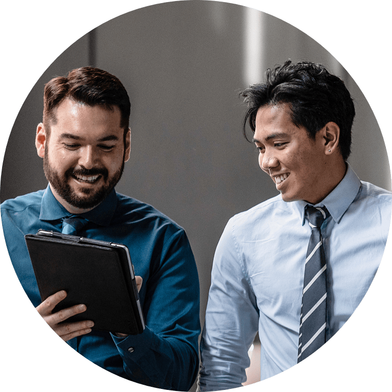 Two males talking together and working on a tablet