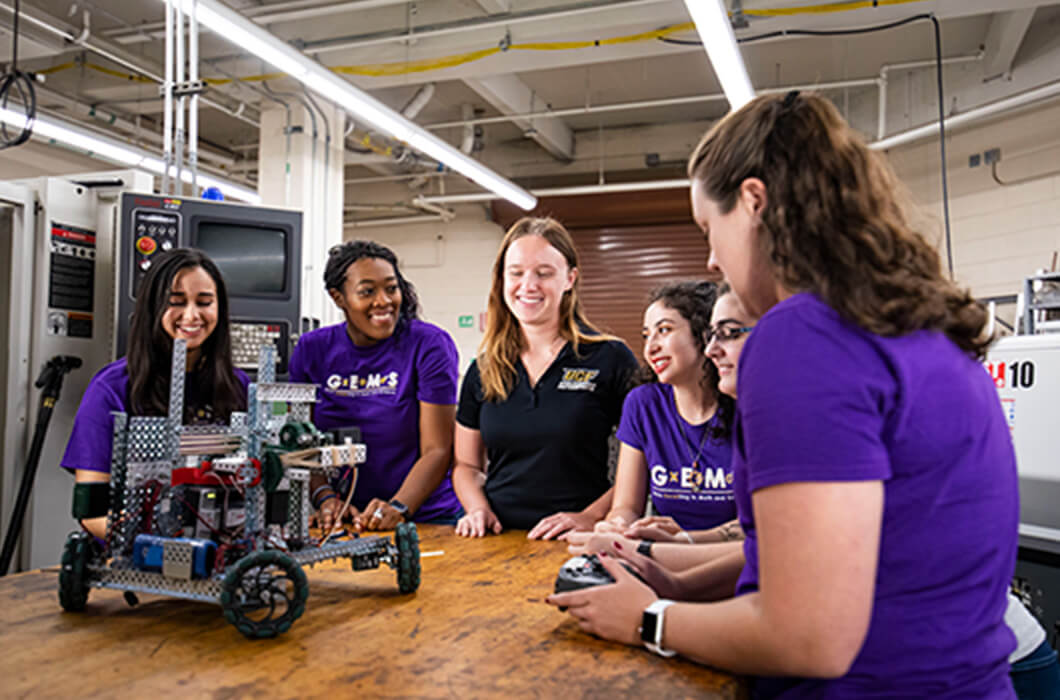 group of female UCF researchers working on a robotics project