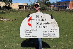 The Rev. James Kjorlaug, senior pastor of First United Methodist Church in Rogers, Ark., holds a church sign that came dislodged following storms that struck the town May 26. Photo courtesy of the Rev. James Kjorlaug.