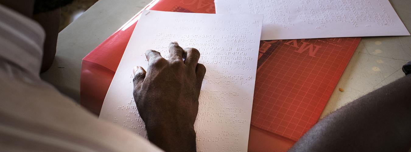 Before Sierra Leone goes to the polls, a training Officer is reading a tactile ballot guide to ensure persons with disabilities know how to vote (2018).