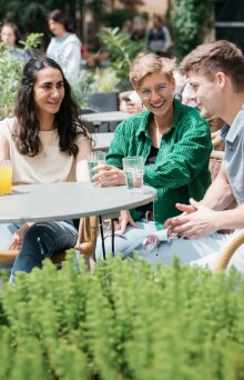 Drei Studierende sitzen in einem Café in der Jenaer Wagnergasse.