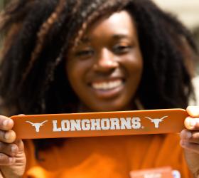 Image of a happy Long Horn student holding a Longhorn banner.